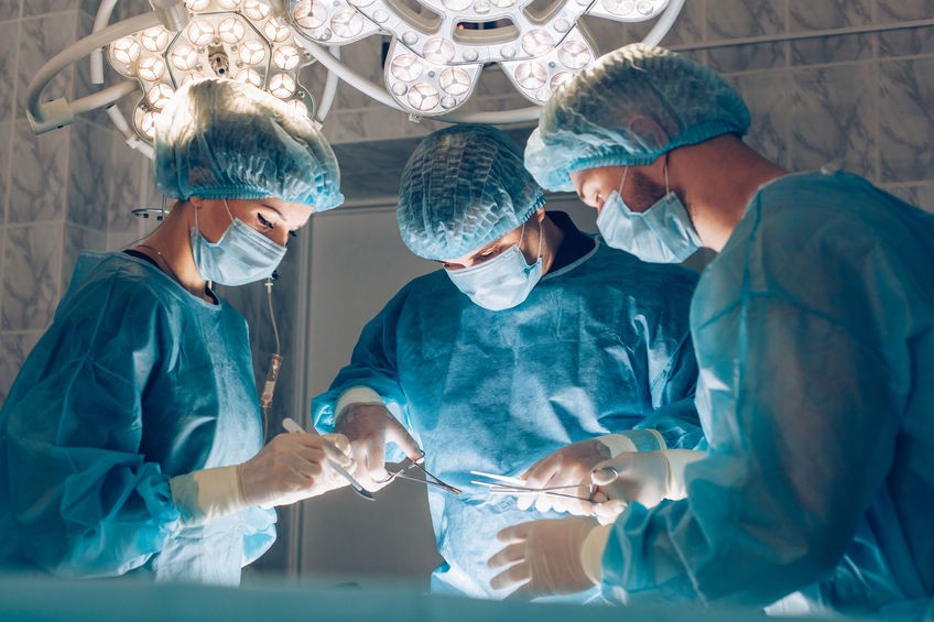 Surgeons team working with Monitoring of patient in surgical operating room breast augmentation